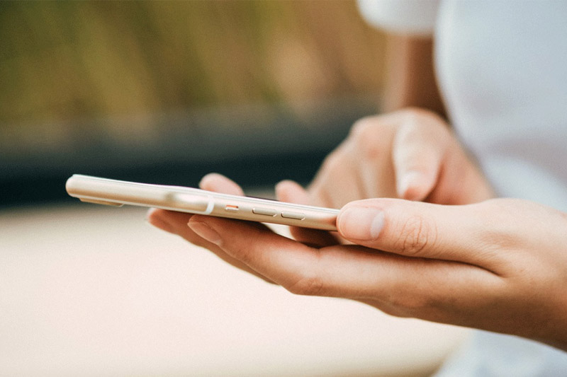 Image of a Hand typing onto a mobile phone