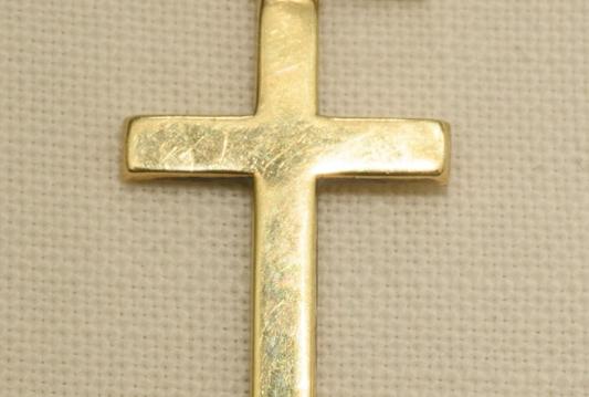 A gold cross on a beige material background
