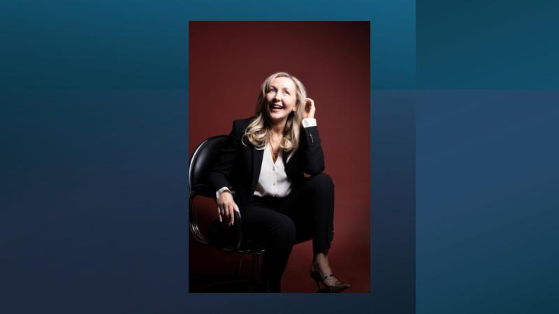 Person sitting on chair laughing left hand in hair.