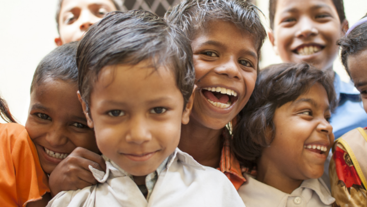 crowd of young children in India smiling at camera