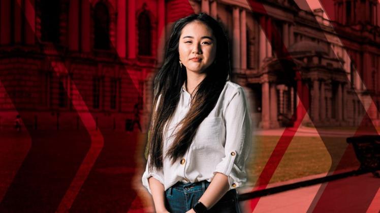 Asian female student standing staring at camera
