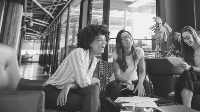 three women chatting and smiling whilst sitting