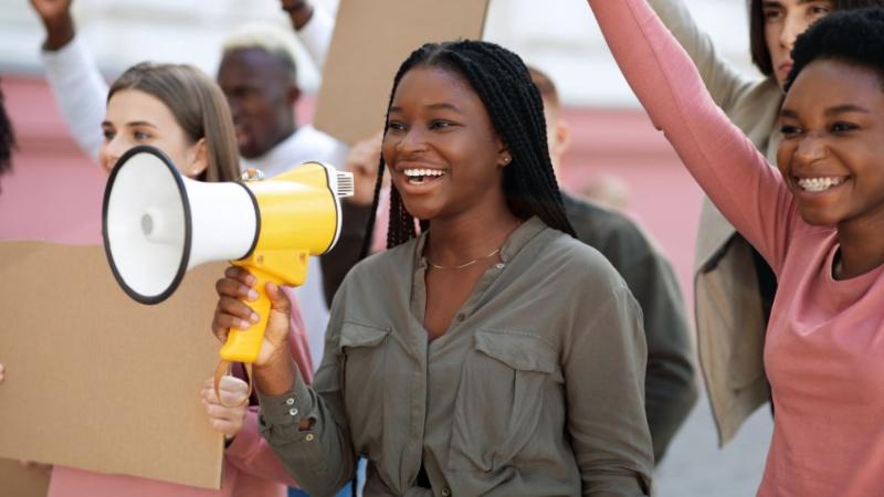 female student shouting through a loudspeaker