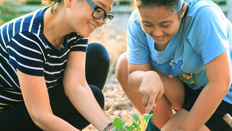 two students gardening