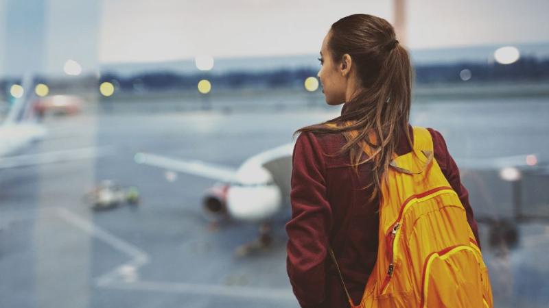 student standing on a runway with a backpack on