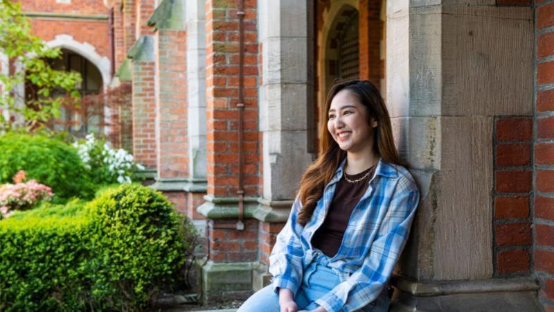 female student sitting in queens university garden