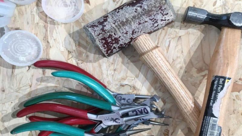 Silversmithing tools on top of a wooden table