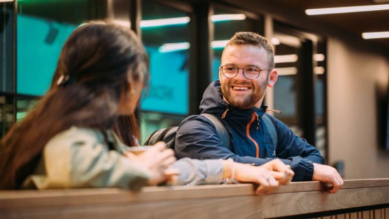 two students standing chatting