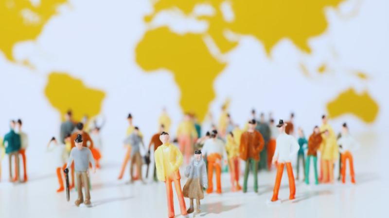 graphic of people standing looking at a map of the world drawn on a wall