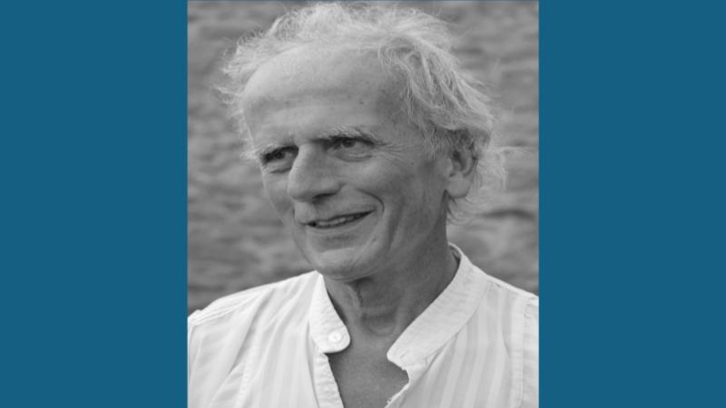 Person smiling looking to side wearing a white shirt.