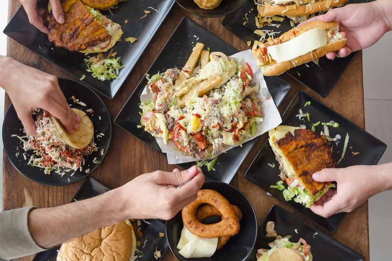 Group sharing small plates of food across a table