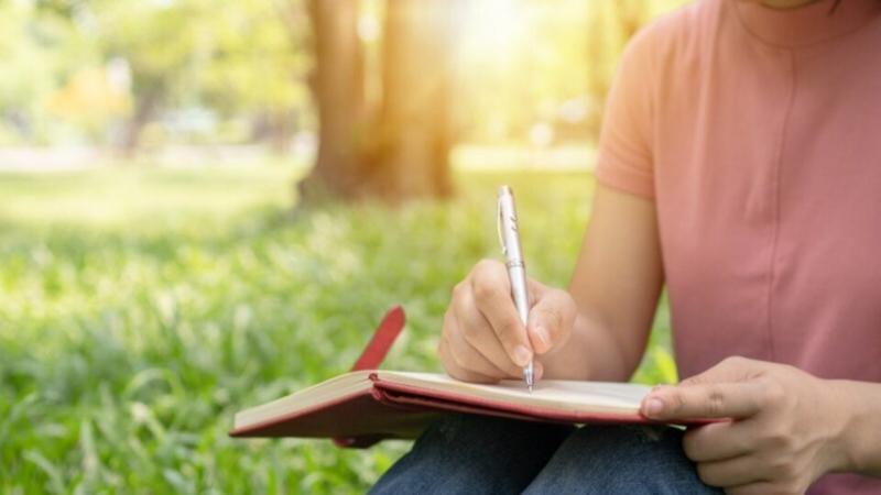 Person writing poetry in notebook