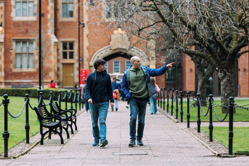 Two men walk through the quad