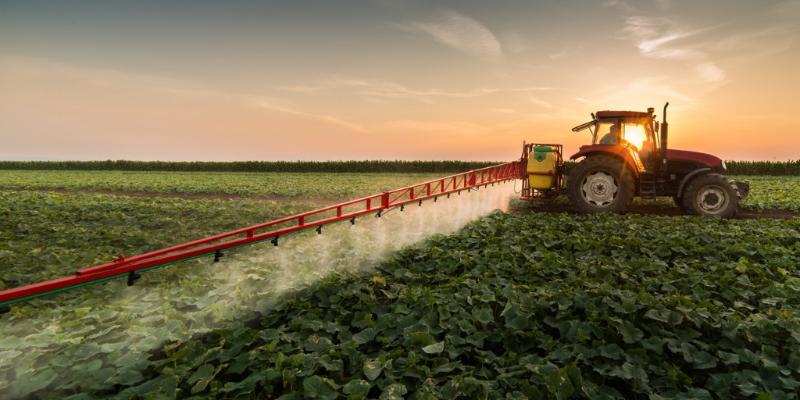 Tractor spraying a field of crops