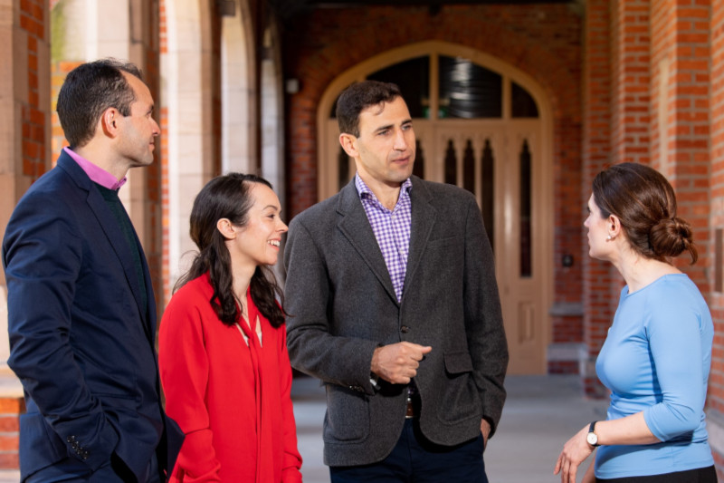 Men and Women talking informally in the Cloisters at Queen's