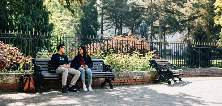 Choo and Sijin sitting on a bench outside Botanic Gardens