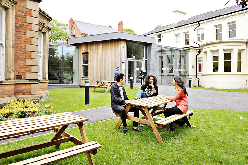 Students seated outside the INTO centre