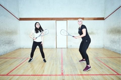 Two girls playing squash