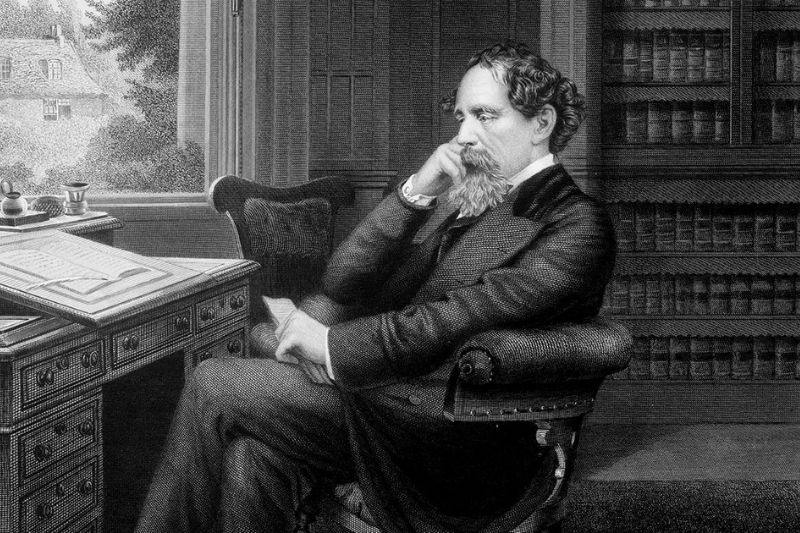 Charles Dickens seated at a desk