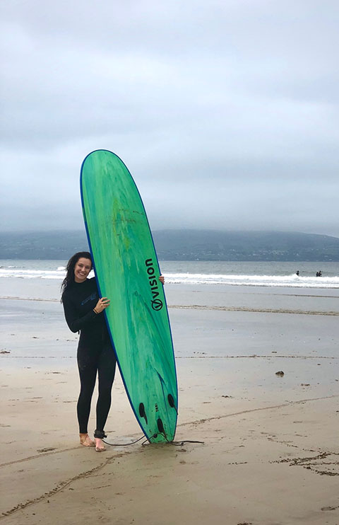Madelyn on Benone strand with a surf board