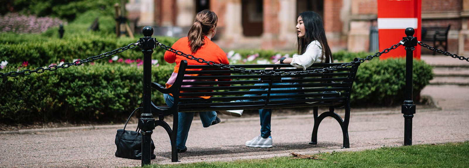 Two students on a bench in the quad
