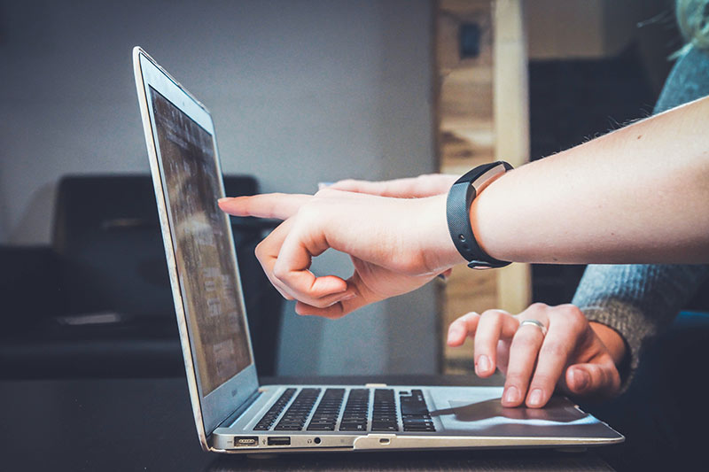 People pointing at laptops