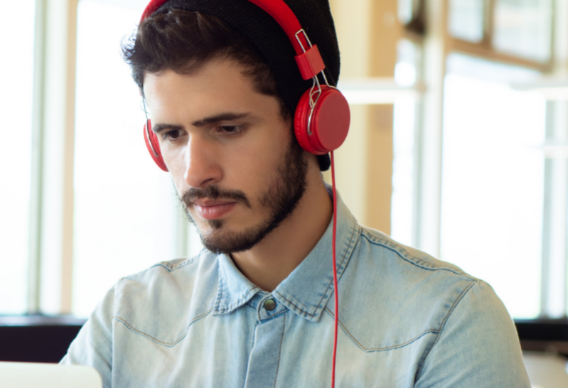 Man sitting at computer with red headphones on