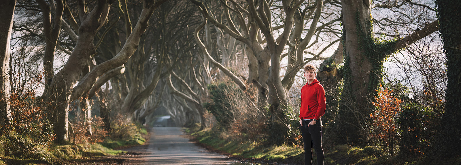Student in red hoodie at the dark hedges