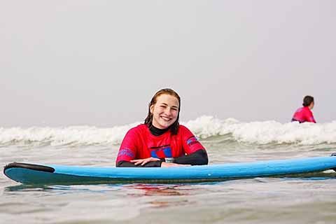 Tessa leaning on a surf board