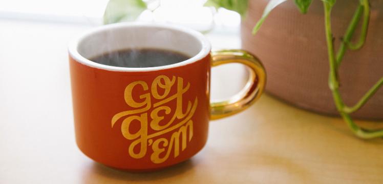 Mug with coffee that has get it done slogan