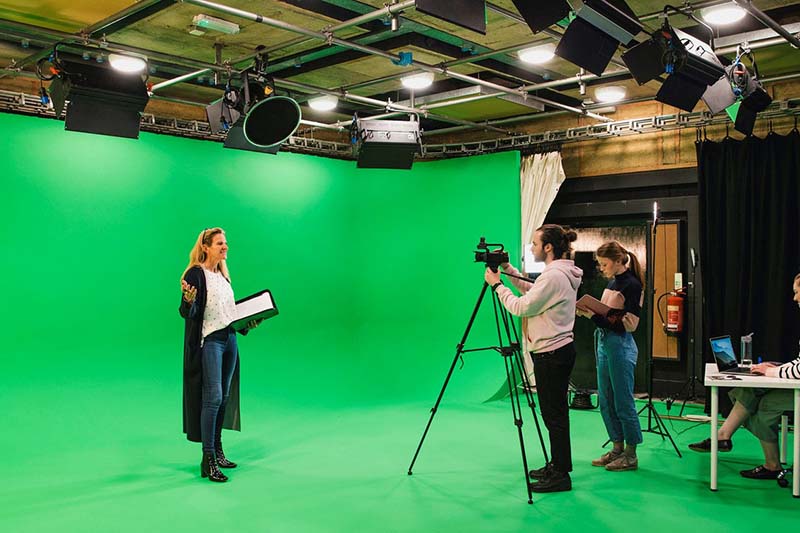 MediaLab -woman standing in front of a green screen