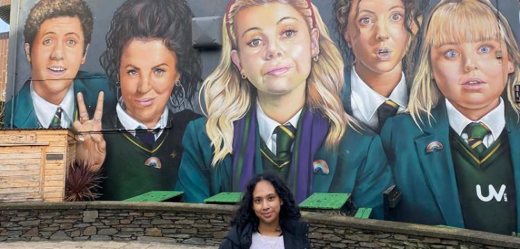 Sumita in front of the Derry Girls mural