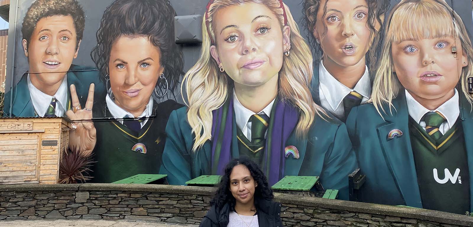 Sumita in front of the Derry Girls mural