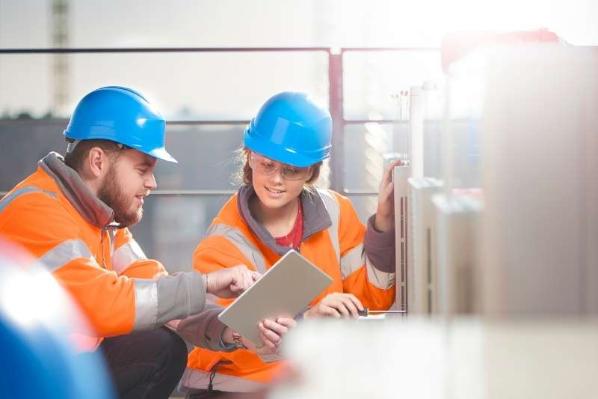 A tradesperson providing training to an apprentice from Queen's