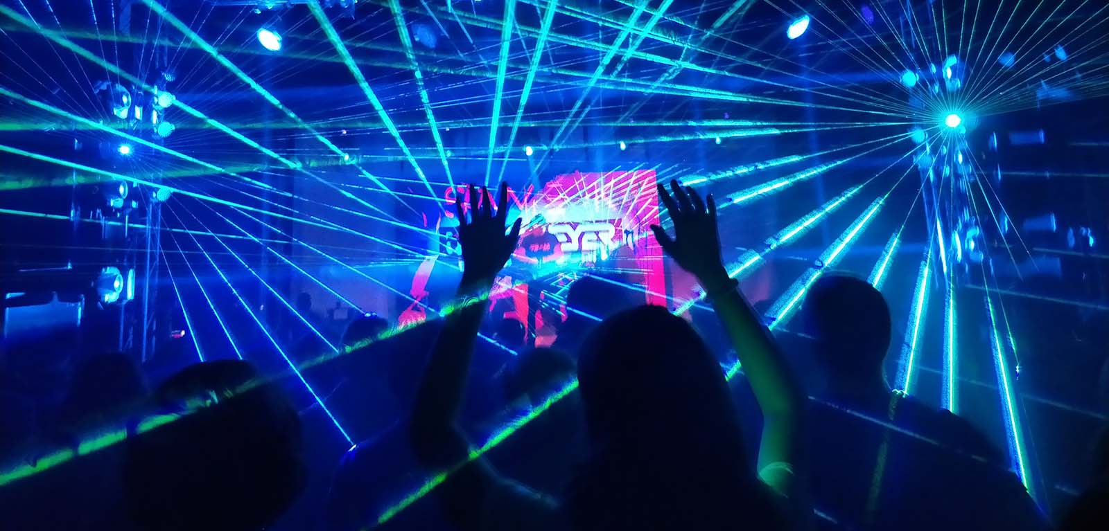 Person dancing in front of lasers