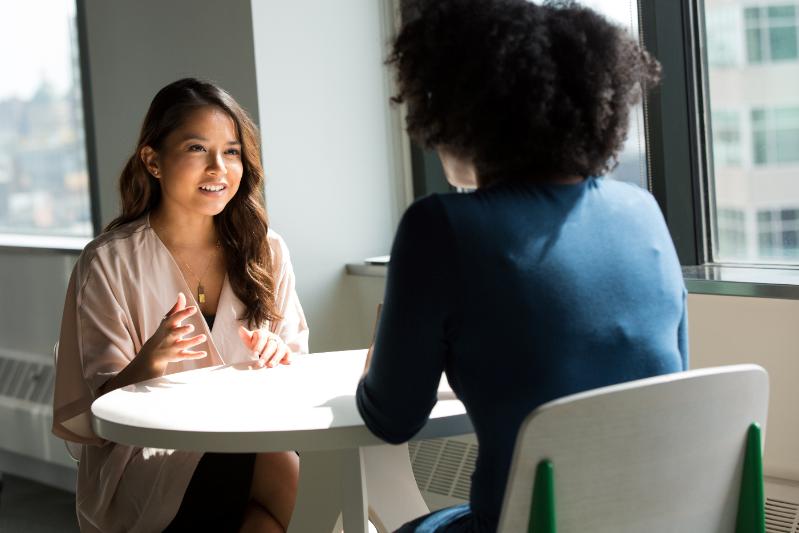 2 women talking at a table