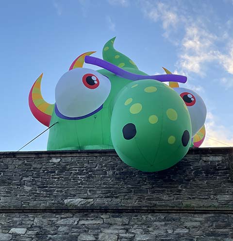 Inflatable monster looking over Derry walls
