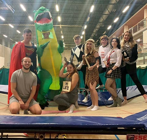 Students in fancy dress on a trampoline