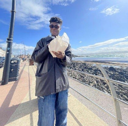 Timothy eating chips by the sea