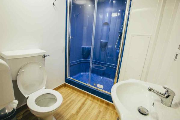 Bathroom with toilet, shower and wash basin.