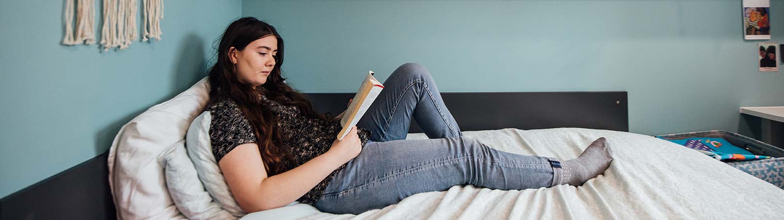 Female student reading on her bed