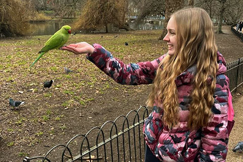 Charlotte with a parakeet on her hand