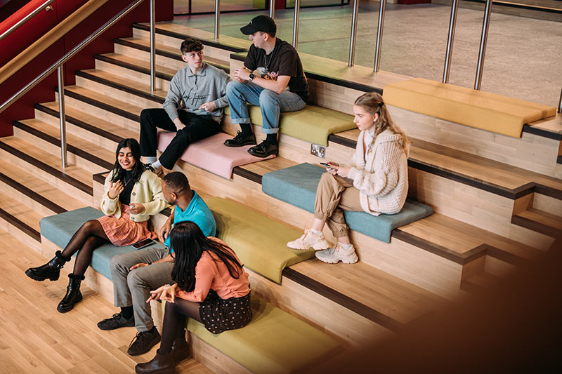 Students sitting on the stairs in One Elmwood