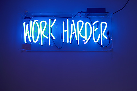 Neon sign that says work harder