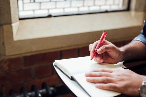 Student writing on notebook