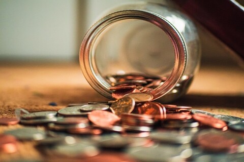 Coins falling out of a glass jar