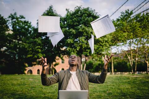 Man throwing sheets of paper in the air