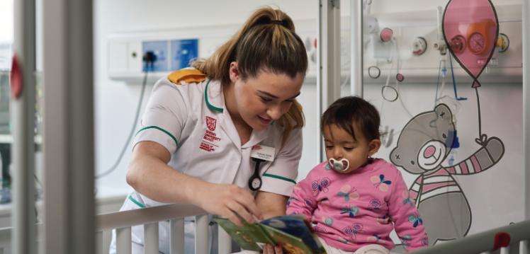 Nursing student with female baby in hospital style setting