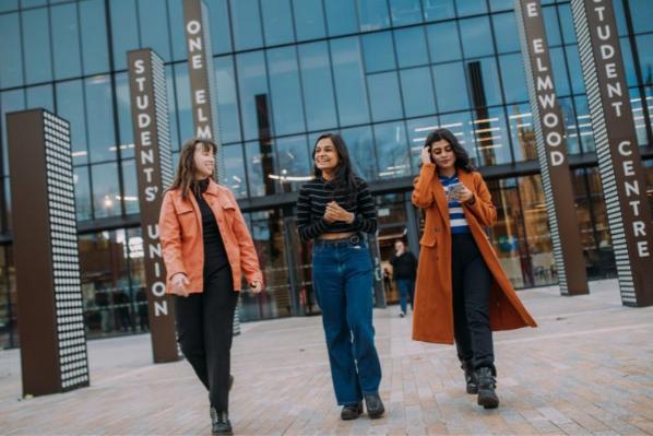 three female students walking outside One Elmwood