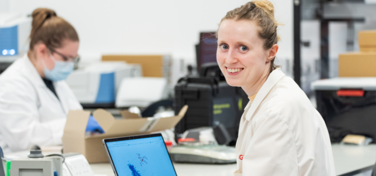 A graduate KTP Associate sitting at a laptop in a lab at Queen's University Belfast